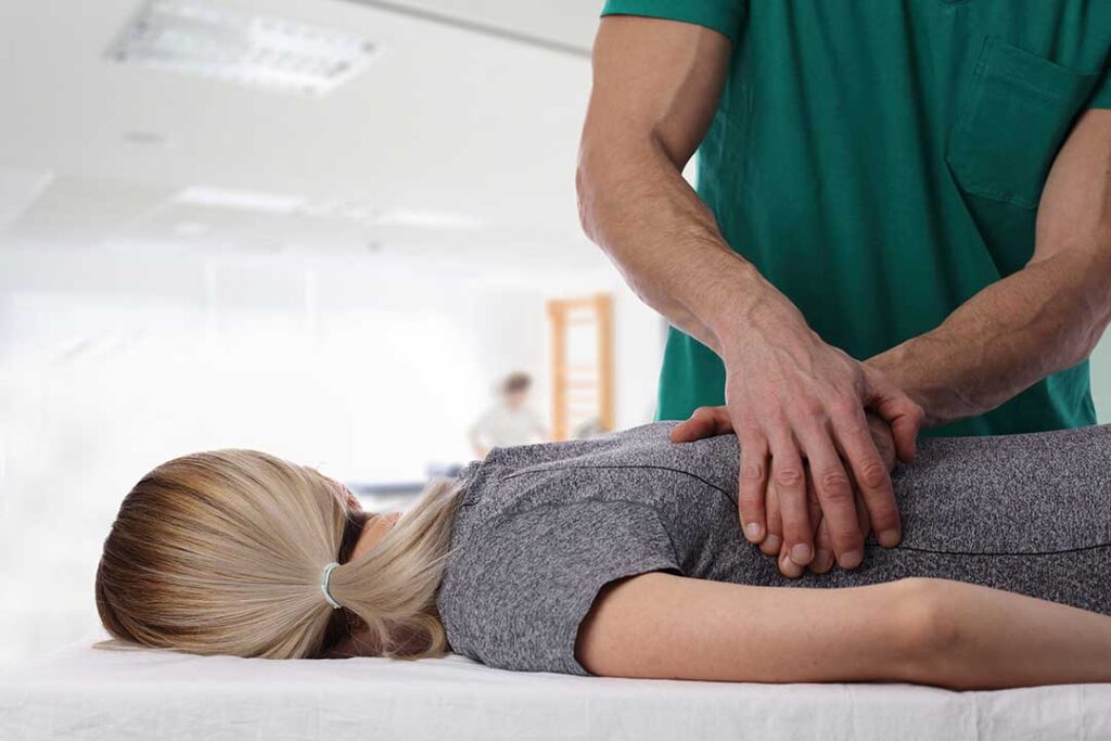 A person gently stretching their fingers with a focused and relaxed expression indoors.