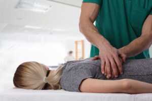 A person gently stretching their fingers with a focused and relaxed expression indoors.