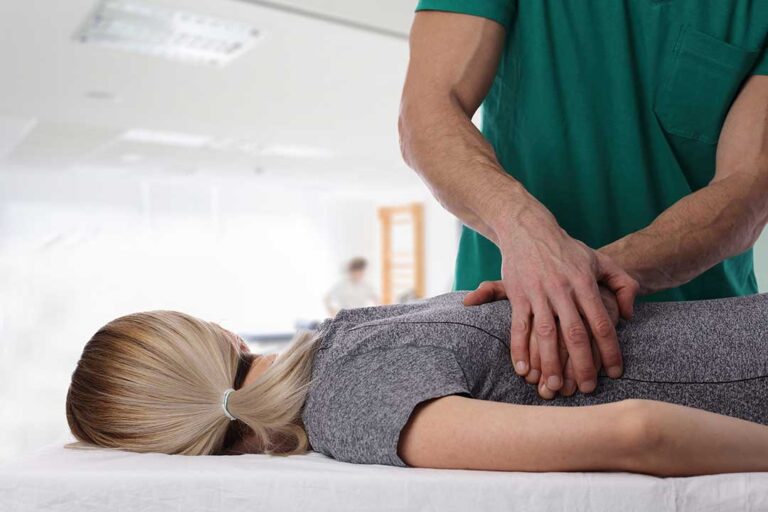 A person gently stretching their fingers with a focused and relaxed expression indoors.