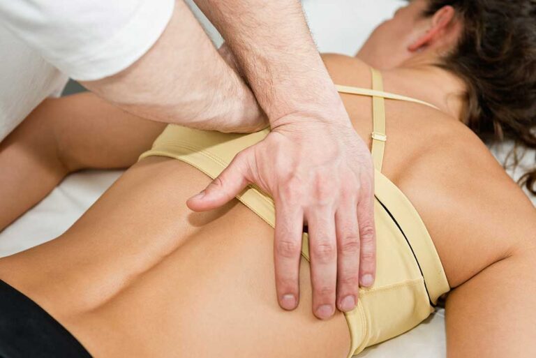 Person rolling to their side and pushing up from bed while managing morning back pain.